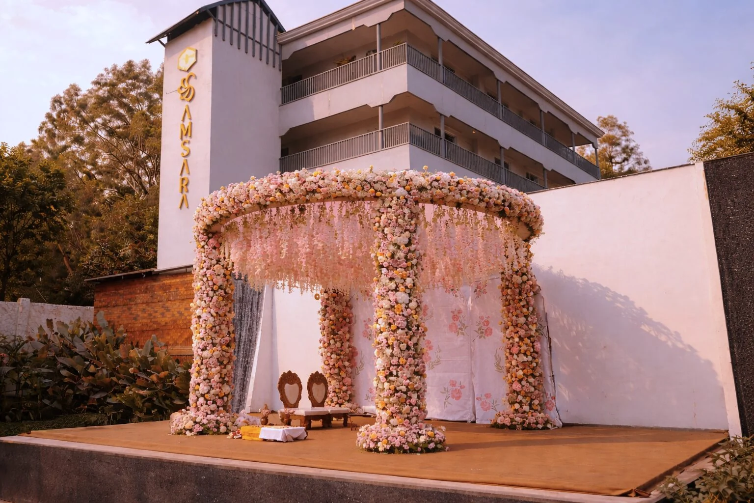 The ceremonial stage dressed with a circular canopy of pink and white flowers