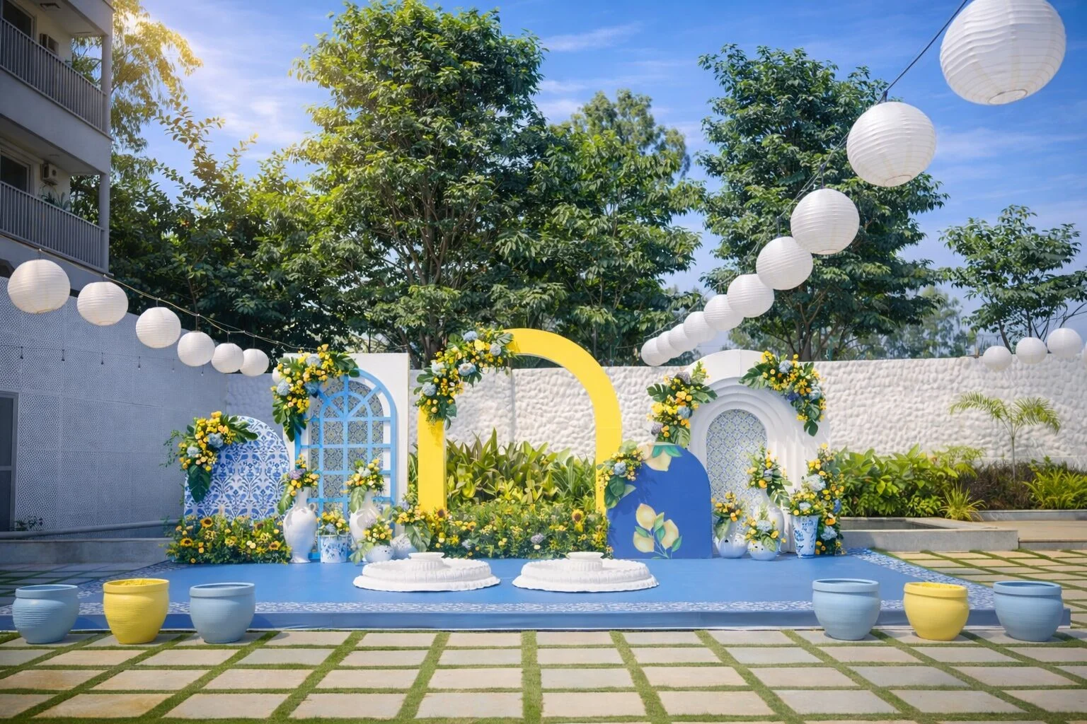 Blue and yellow ceremony décor beneath paper lanterns at Aavya Poolside Court