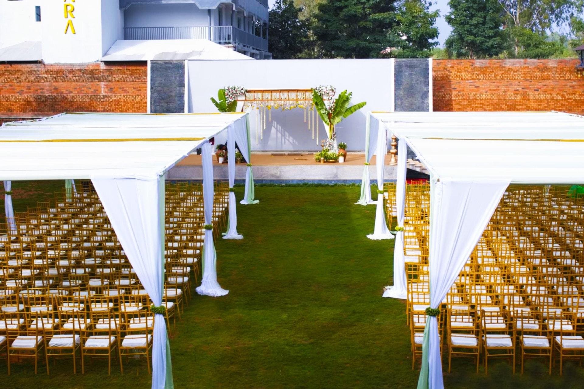 Padma Lawns set for a ceremony, with draped canopies and an aisle to the mandap