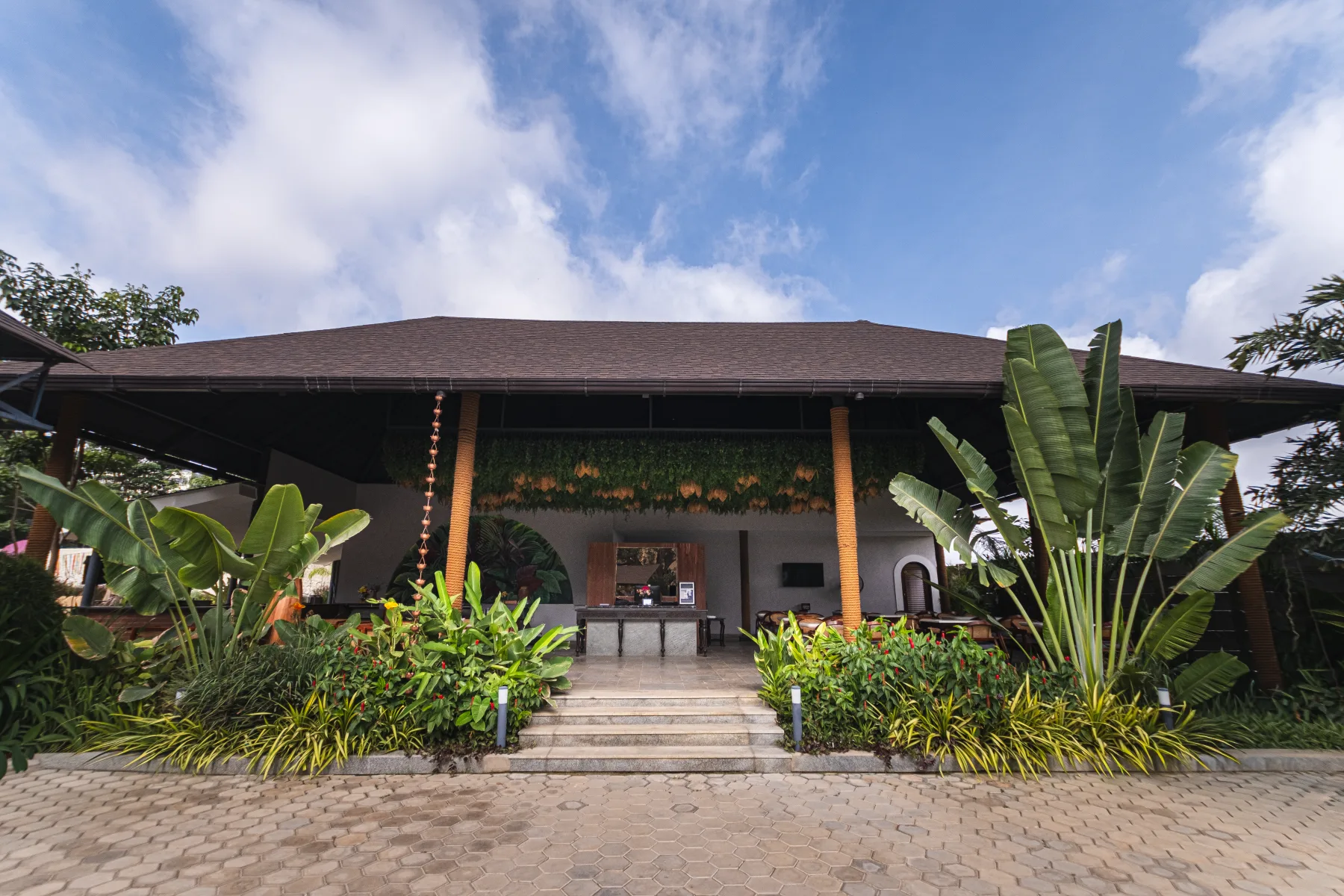 Samsara’s open reception entrance framed by tropical planting in daylight