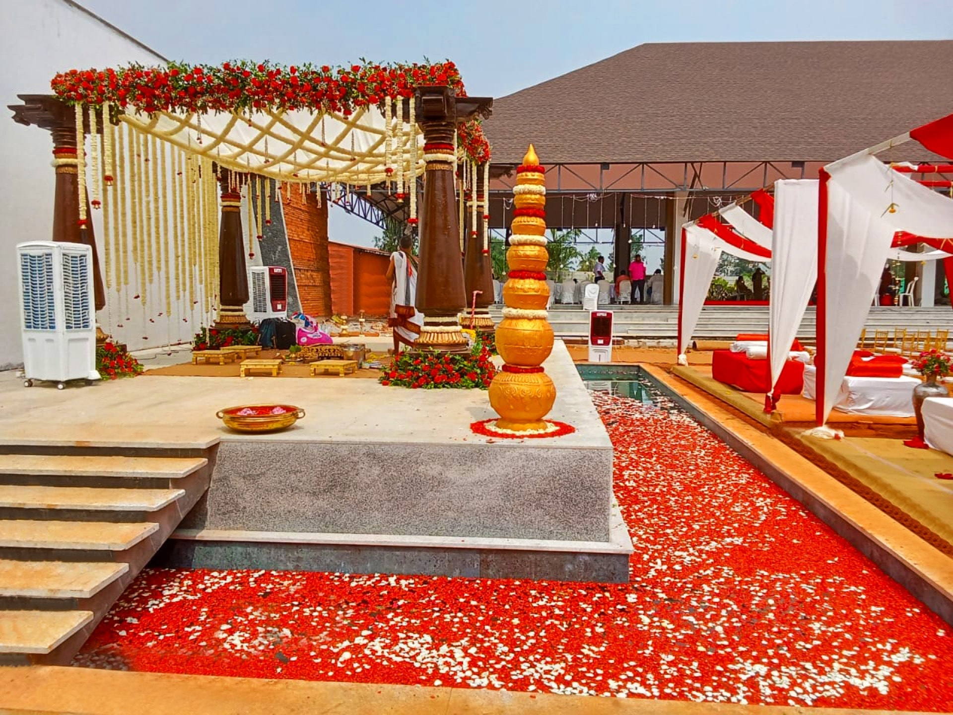 Traditional mantapa with golden kalash and rose petals on floating stage